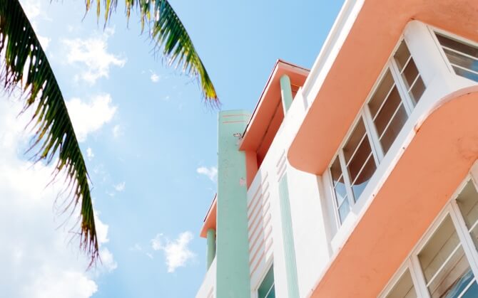 A building on a sunny day with blue skies and a palm tree visible