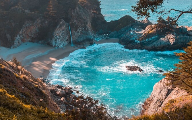 A protected cove with a beach next to the ocean