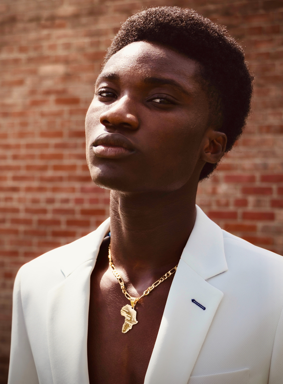 A woman looking at the camera and wearing a necklace